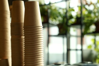 Photo of Stacks of takeaway paper coffee cups in cafe, space for text