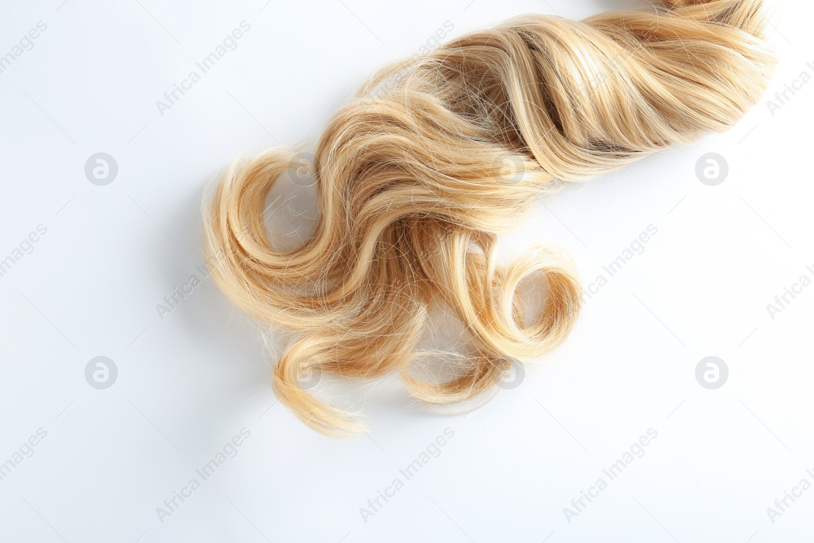 Photo of Beautiful curly blonde hair on white background, top view. Hairdresser service