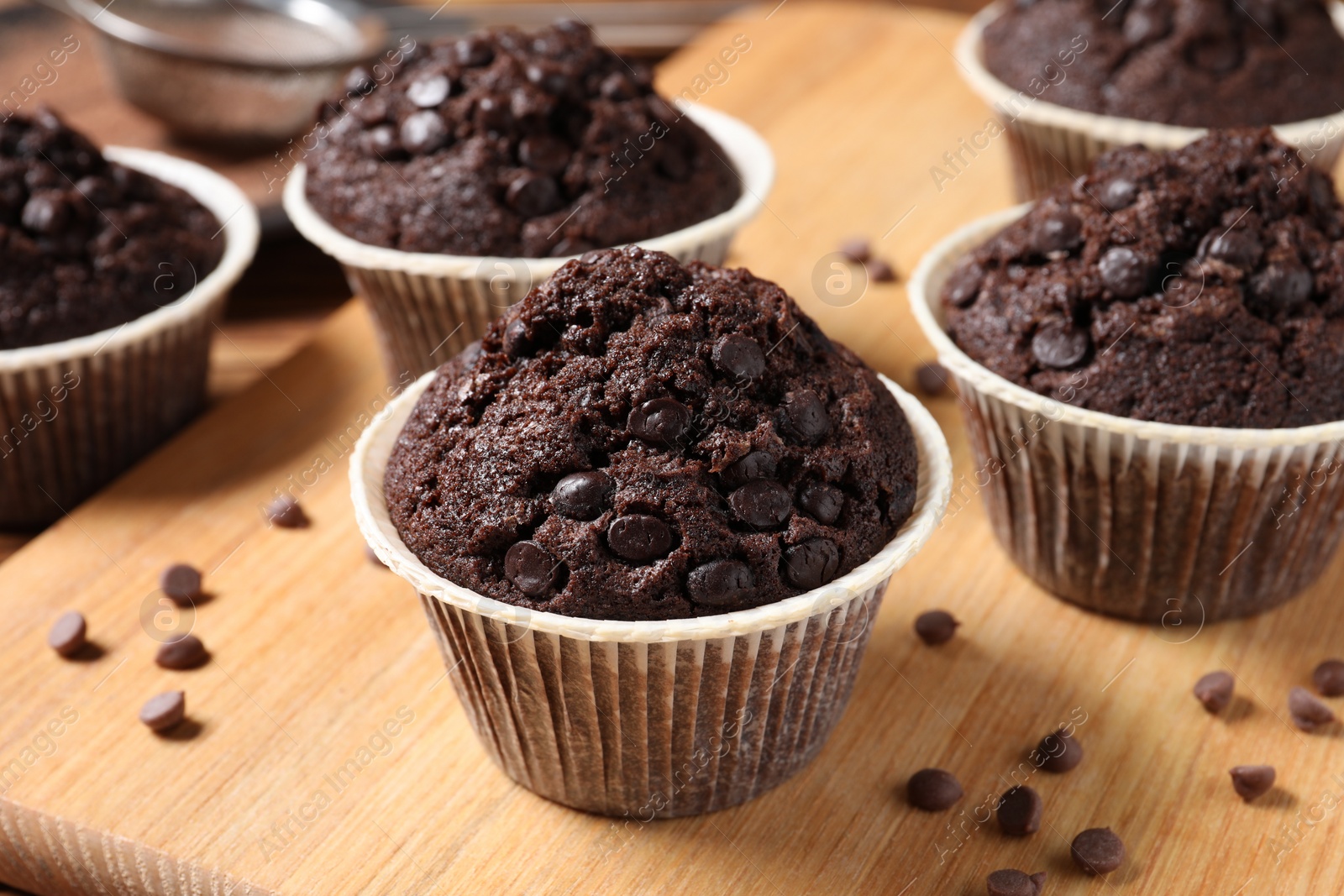 Photo of Tasty chocolate muffins on wooden table, closeup