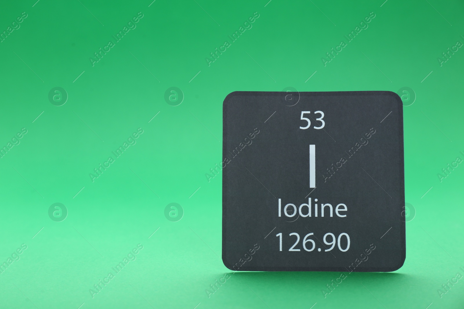 Photo of Card with iodine element on green background. Space for text