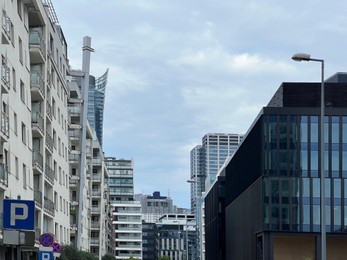 Photo of City street with beautiful buildings under cloudy sky