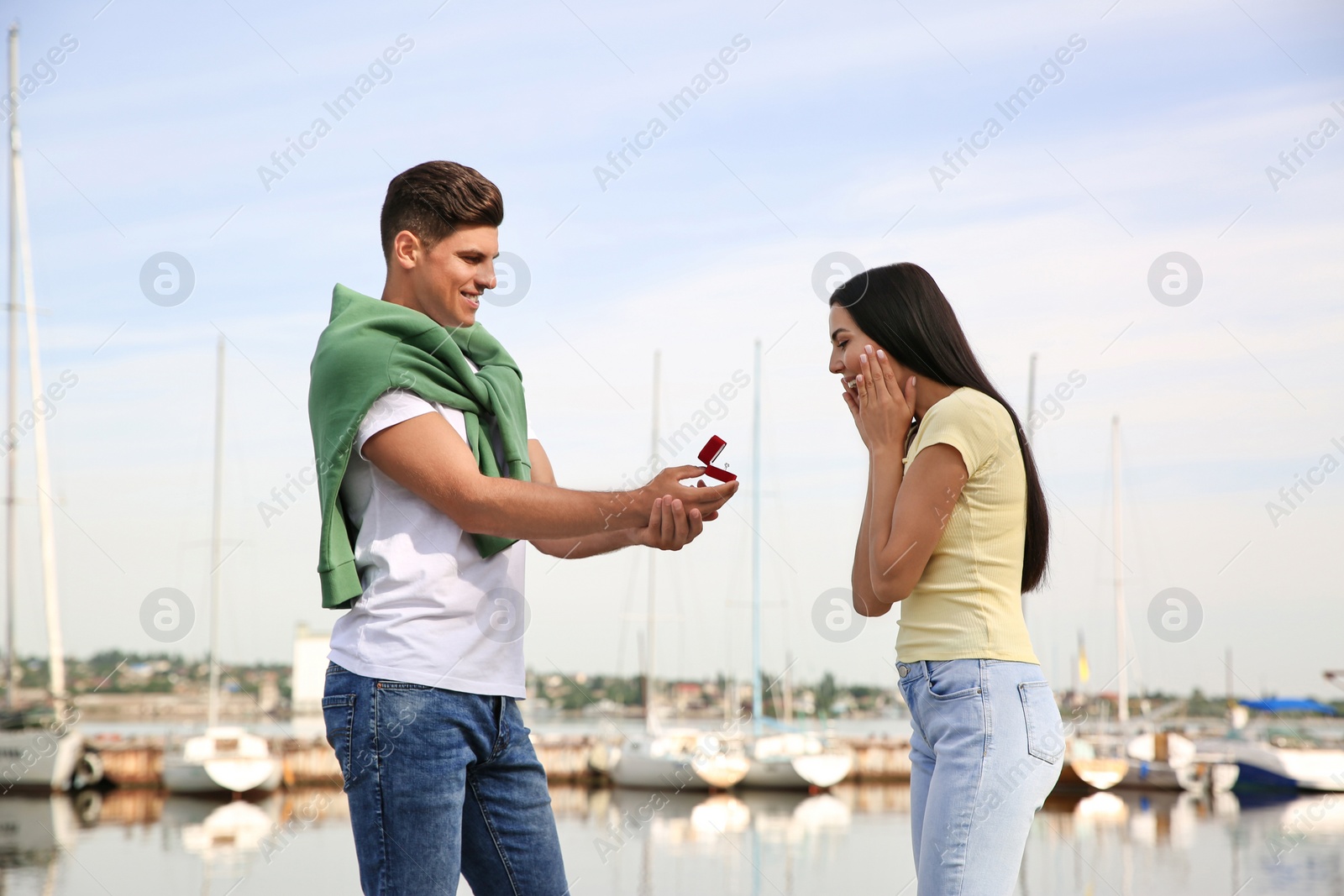 Photo of Man with engagement ring making proposal to his girlfriend near river