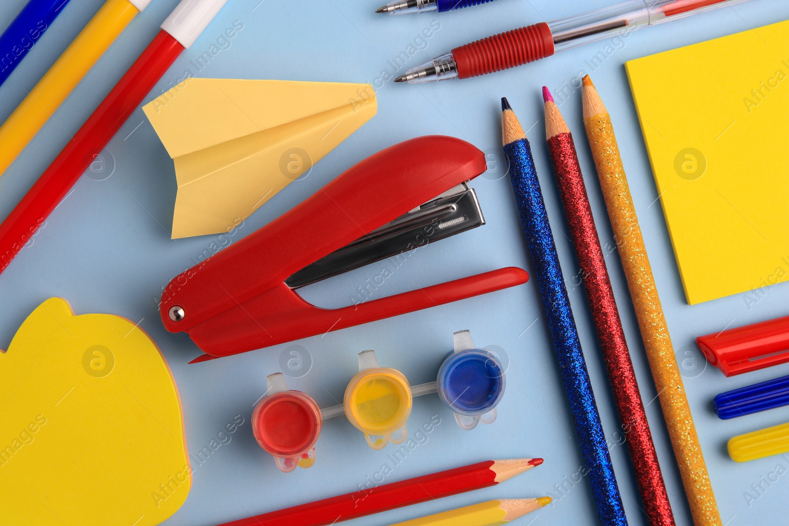 Photo of Flat lay composition with sticky note and other school stationery on light blue background, space for text. Back to school