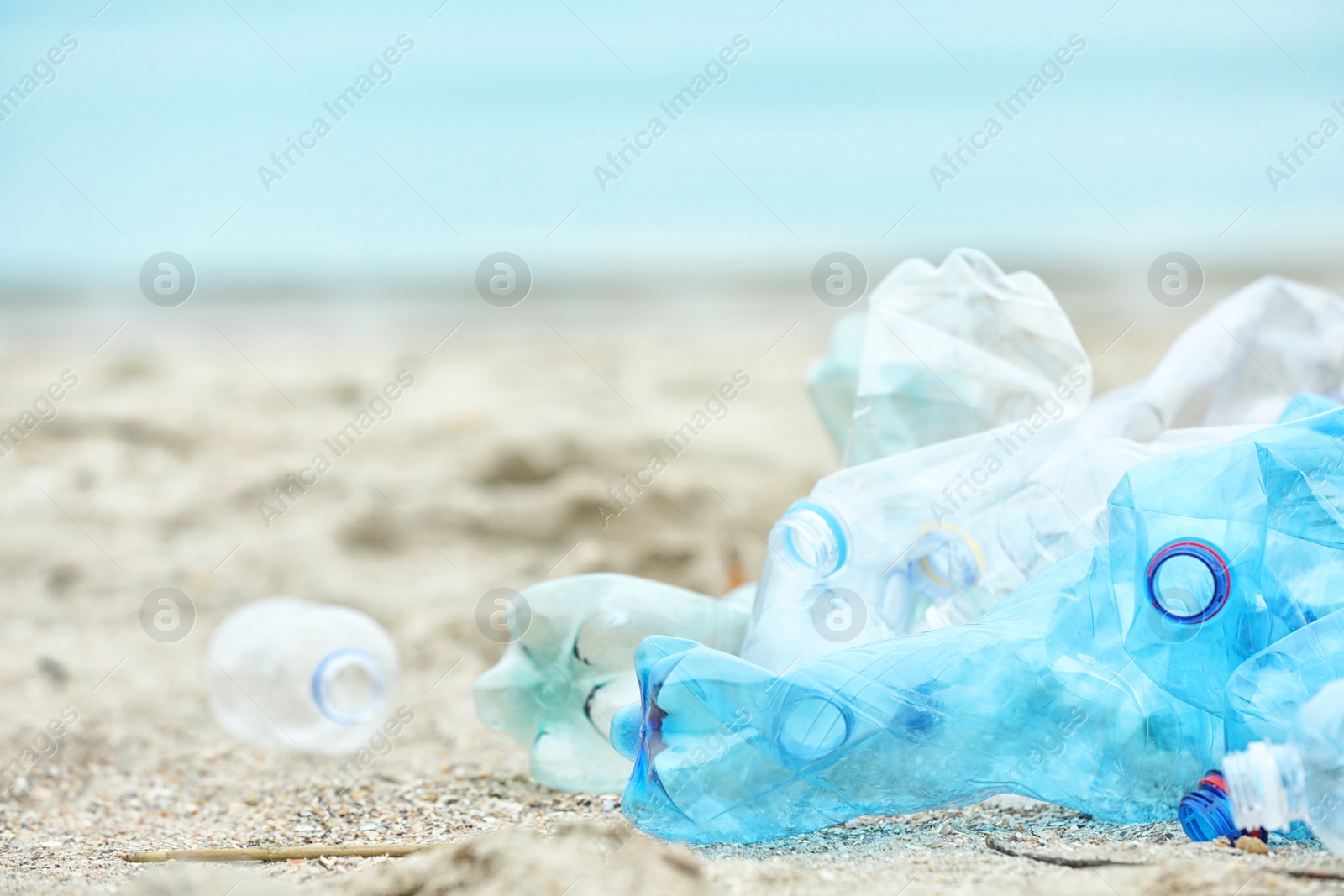 Photo of Used plastic bottles on beach, space for text. Recycling problem