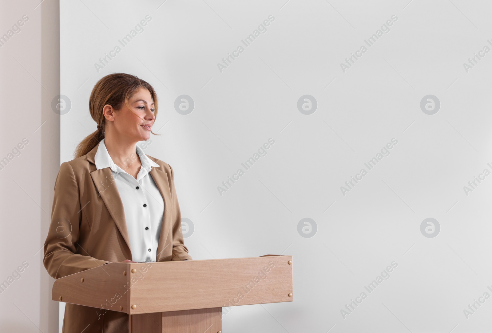 Photo of Business trainer giving lecture in conference room with projection screen. Space for design