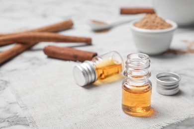 Photo of Closeup of bottle with cinnamon oil on light background