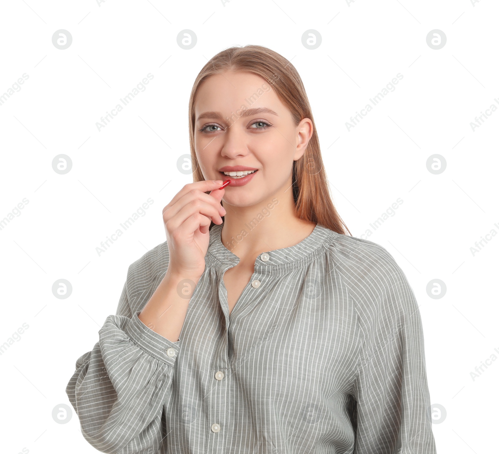 Photo of Young woman taking vitamin capsule on white background