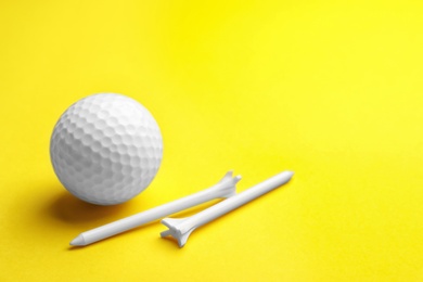 Photo of Golf ball and tees on color background, space for text. Sport equipment