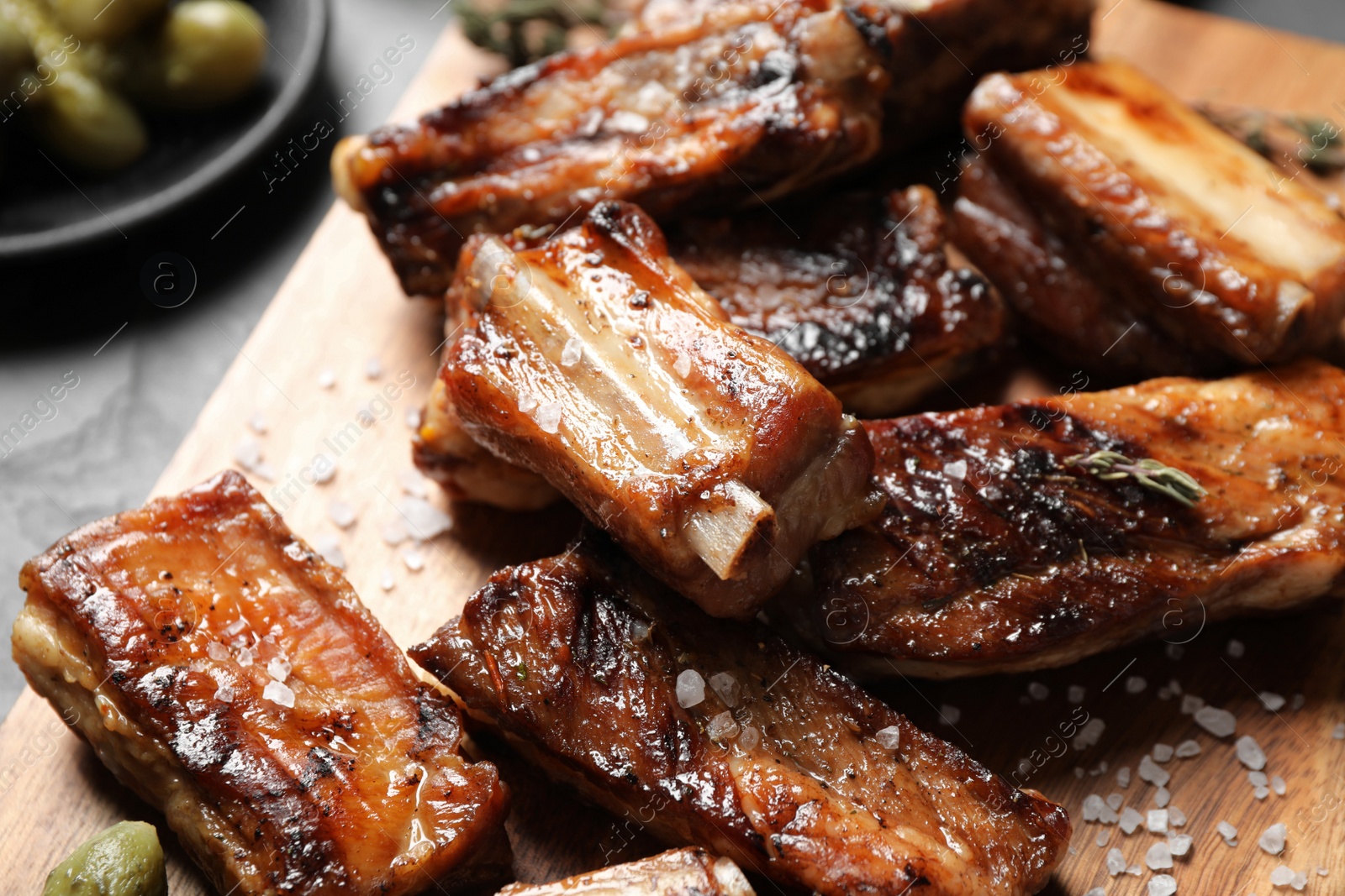 Photo of Delicious grilled ribs served on table, closeup