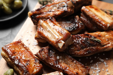 Photo of Delicious grilled ribs served on table, closeup