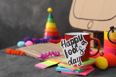 Photo of Cup with words Happy Fool's Day at fake workplace in office