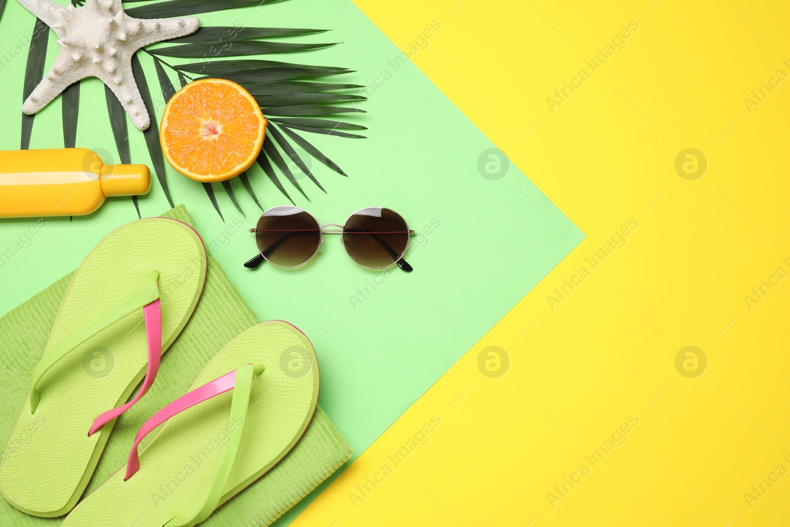 Photo of Beach accessories on yellow background, flat lay. Space for text