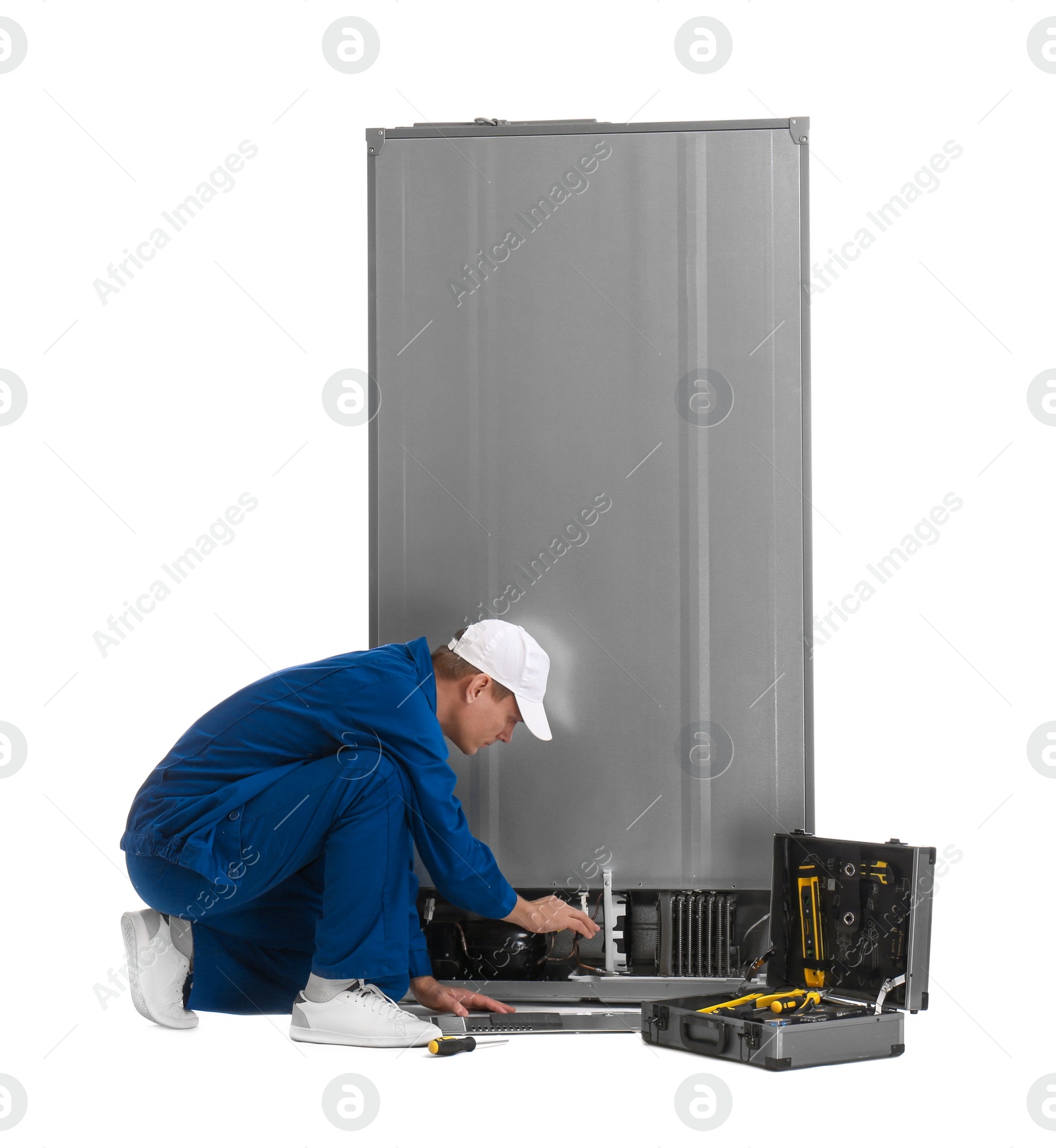 Photo of Male technician repairing refrigerator on white background