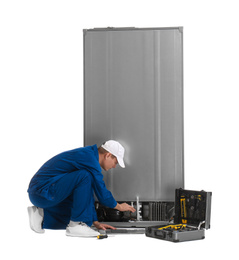 Photo of Male technician repairing refrigerator on white background