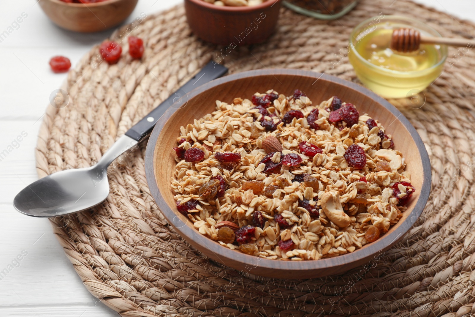 Photo of Tasty granola served with nuts and dry fruits on white wooden table