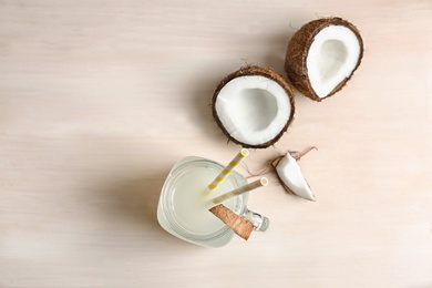 Mason jar with coconut water and fresh nuts on table, top view