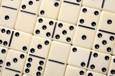 Photo of Set of classic domino tiles as background, top view
