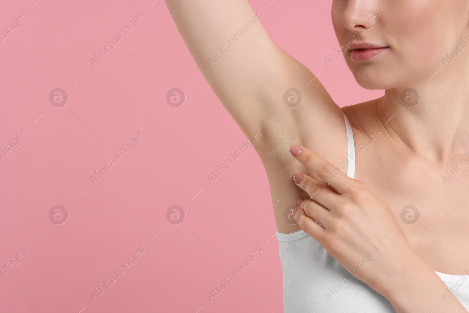 Photo of Woman showing armpit with smooth clean skin on pink background, closeup. Space for text