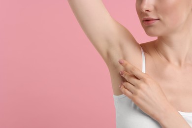 Photo of Woman showing armpit with smooth clean skin on pink background, closeup. Space for text