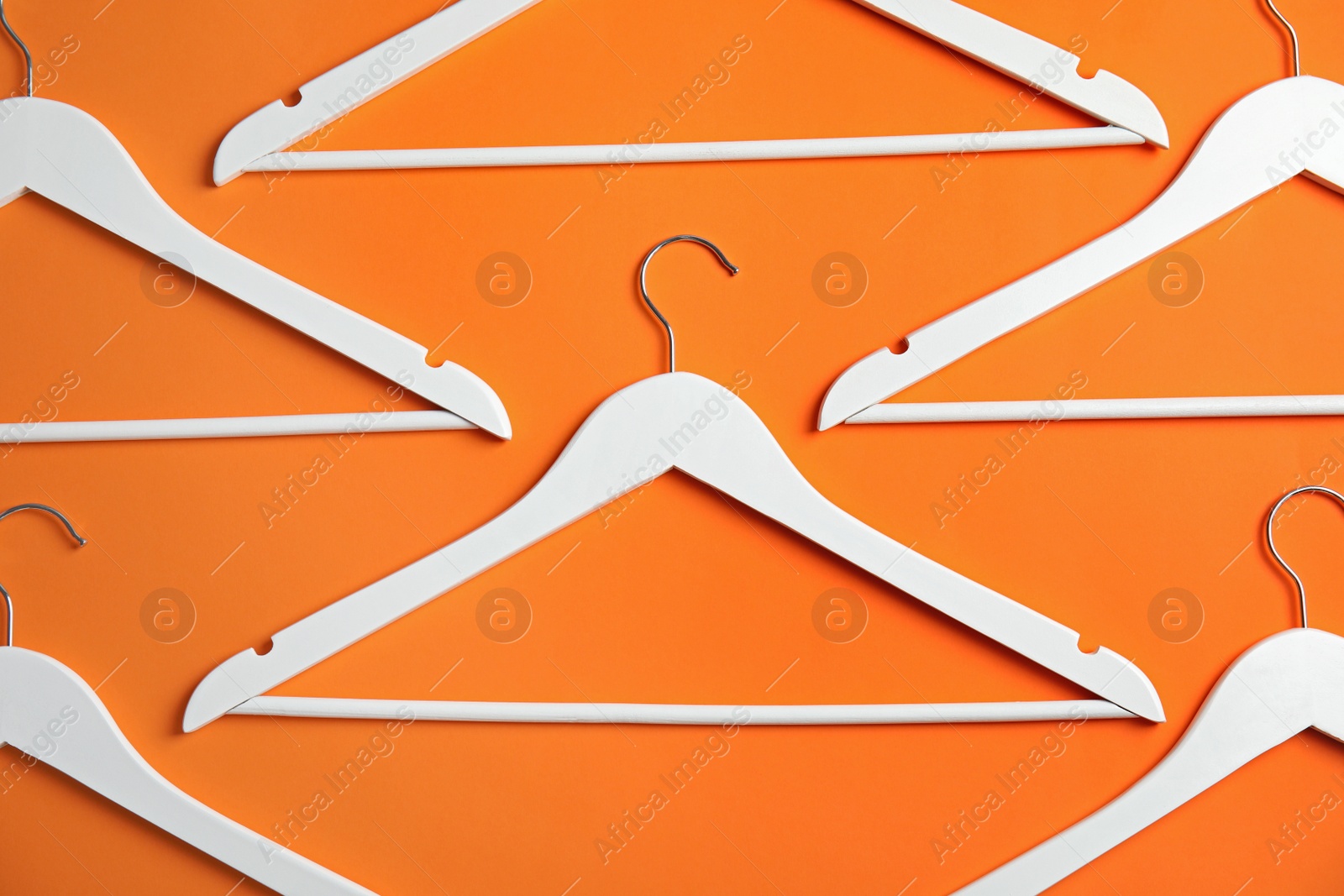 Photo of Flat lay composition with empty hangers on color background