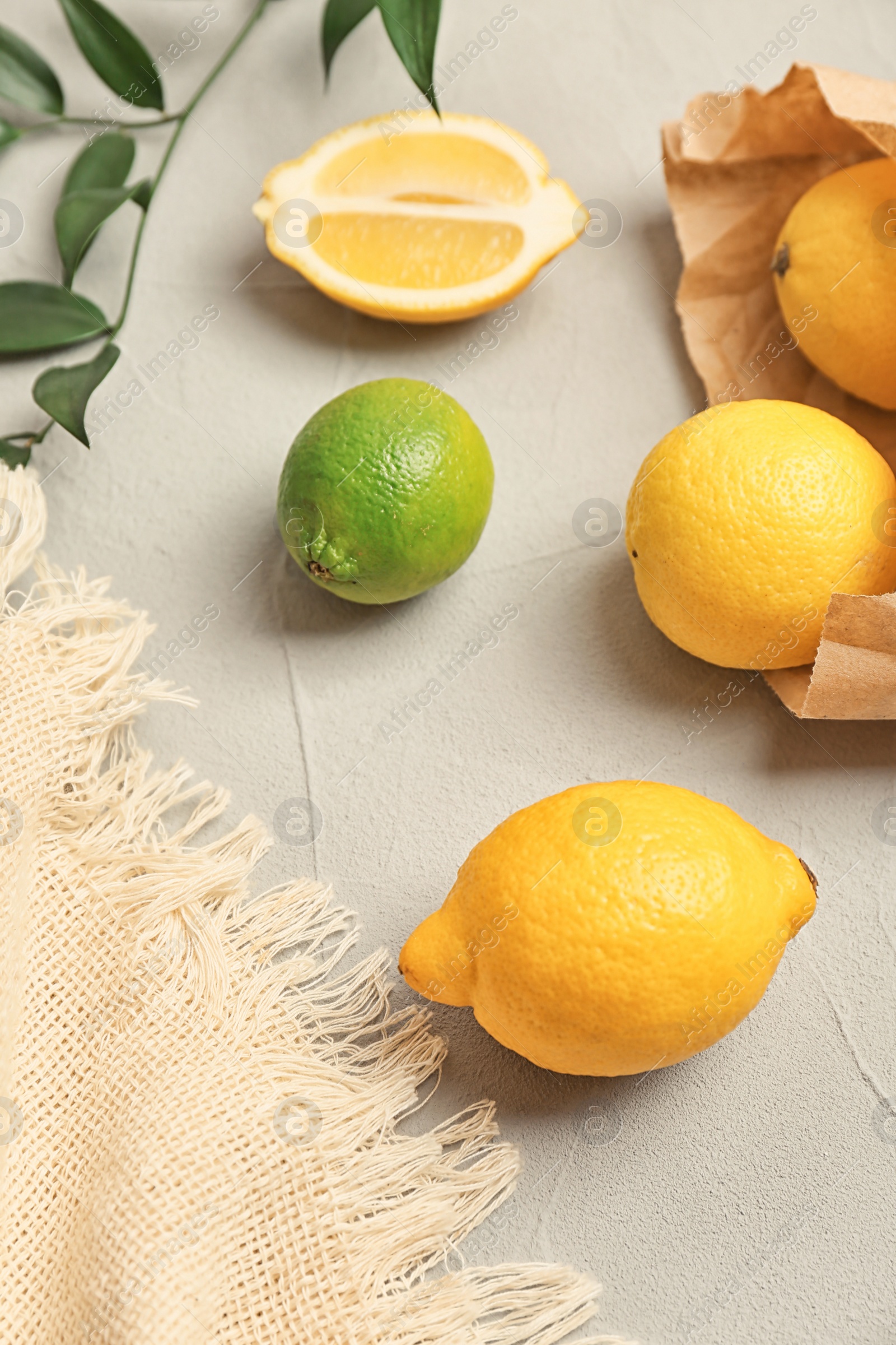 Photo of Fresh lemons and lime on grey table