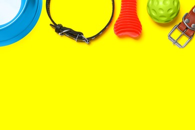 Photo of Flat lay composition with dog collar and toys on yellow background. Space for text