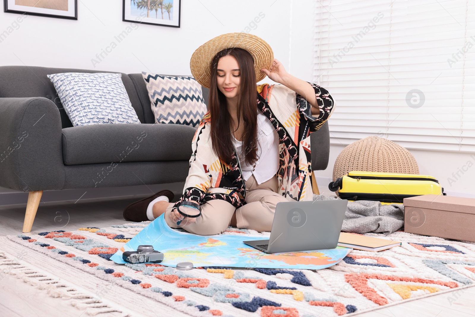 Photo of Travel blogger with magnifying glass and map planning trip at home