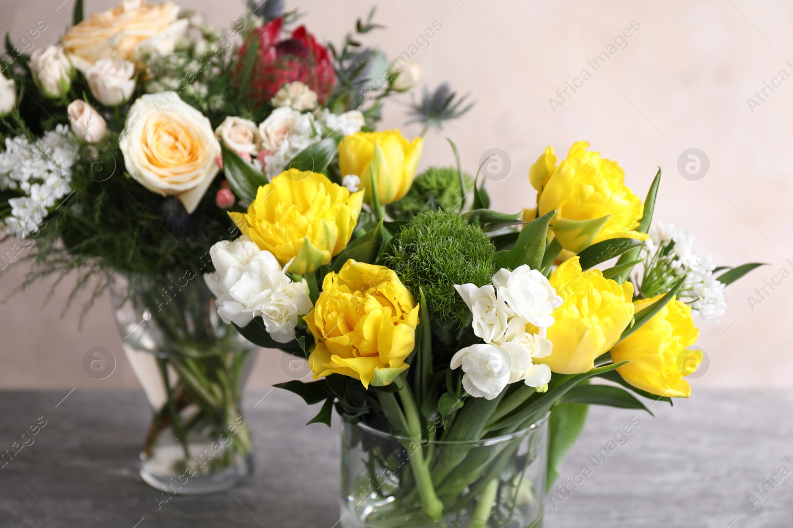 Photo of Beautiful bouquets with fresh flowers on grey table, closeup