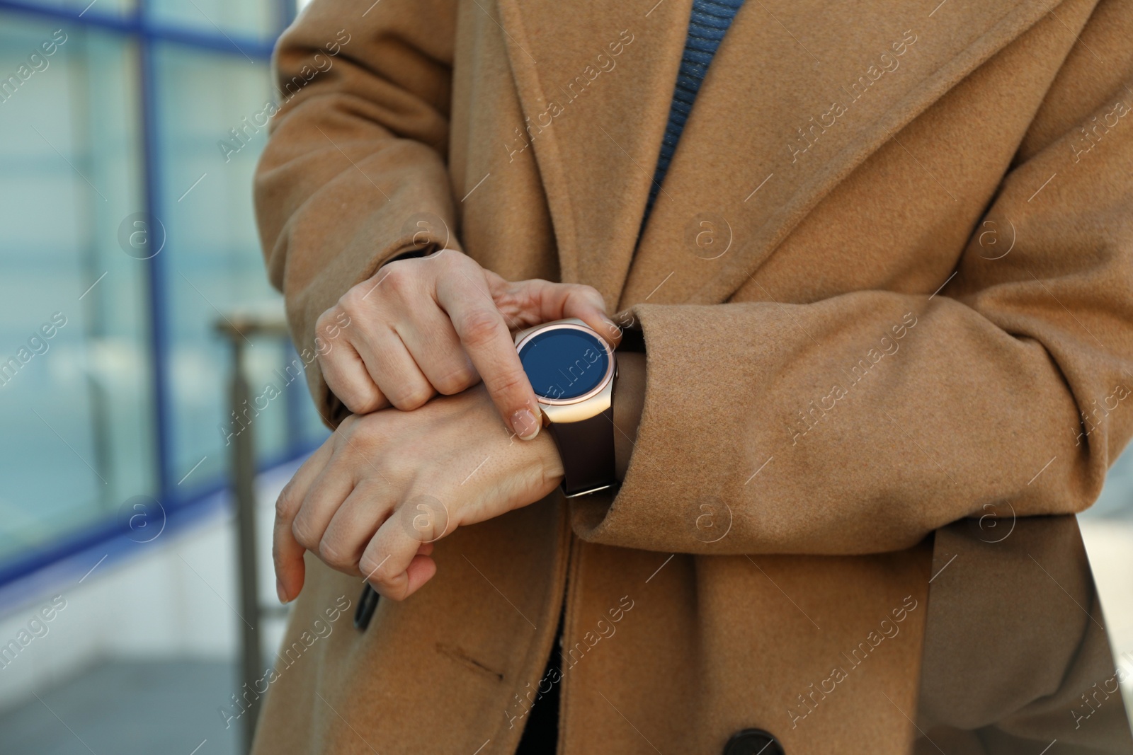 Photo of Mature woman using smart watch outdoors, closeup