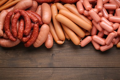 Photo of Different delicious sausages on wooden table, flat lay. Space for text