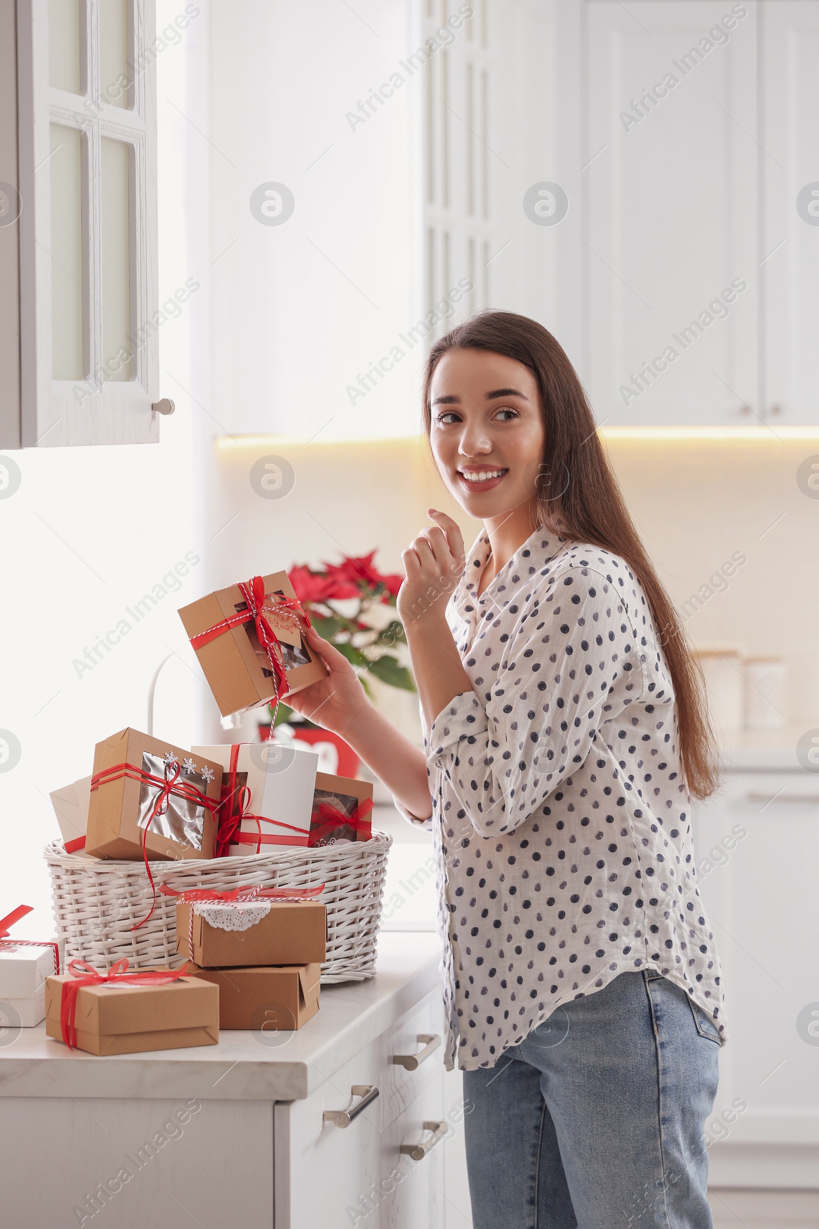 Photo of Woman with Christmas gifts at home. Advent calendar in basket