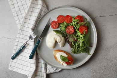 Delicious burrata cheese with tomatoes, arugula and toast served on grey table, top view