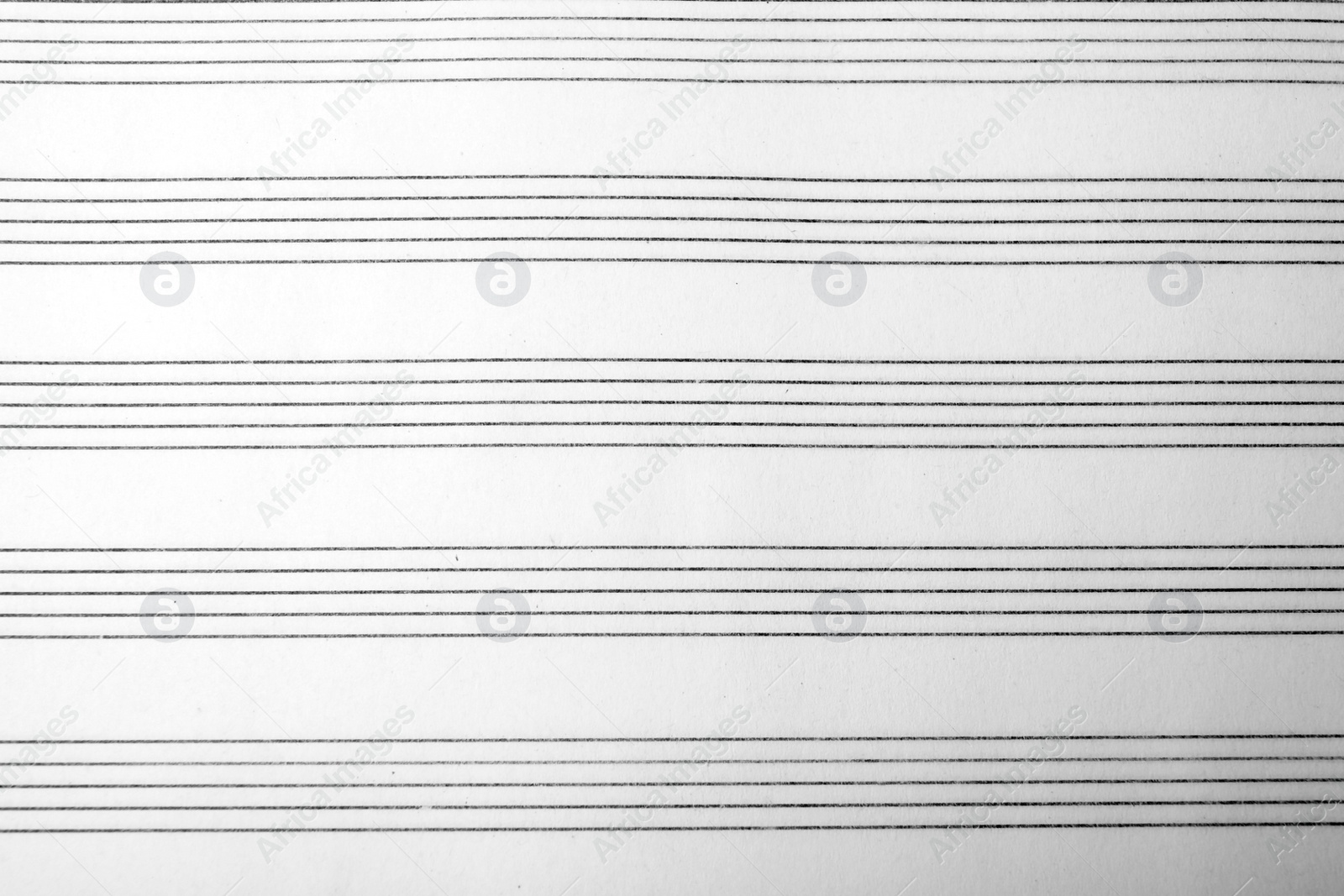 Photo of Paper with empty staves for music notes as background, top view