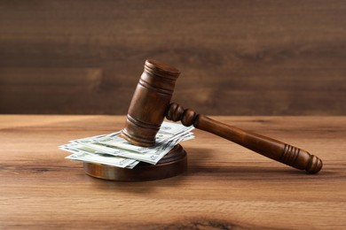 Judge's gavel and money on wooden table