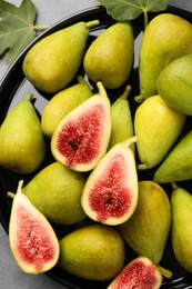 Cut and whole green figs on table, top view
