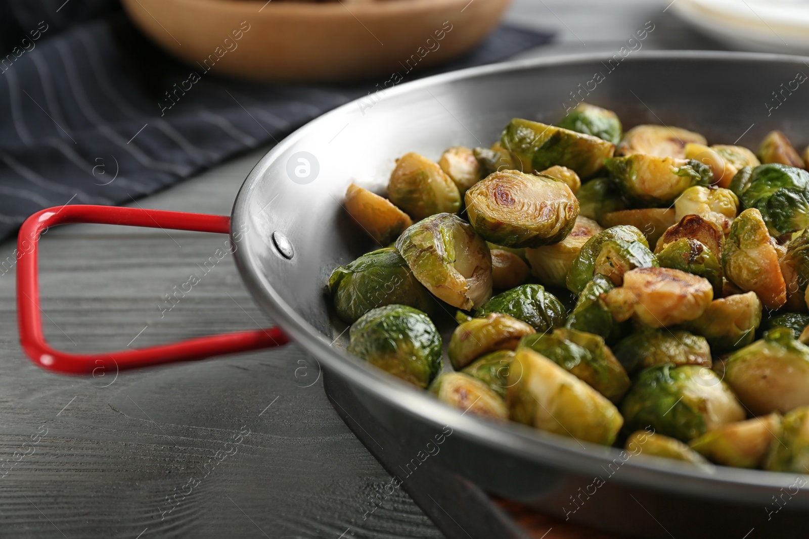 Photo of Delicious roasted brussels sprouts on grey wooden table, closeup