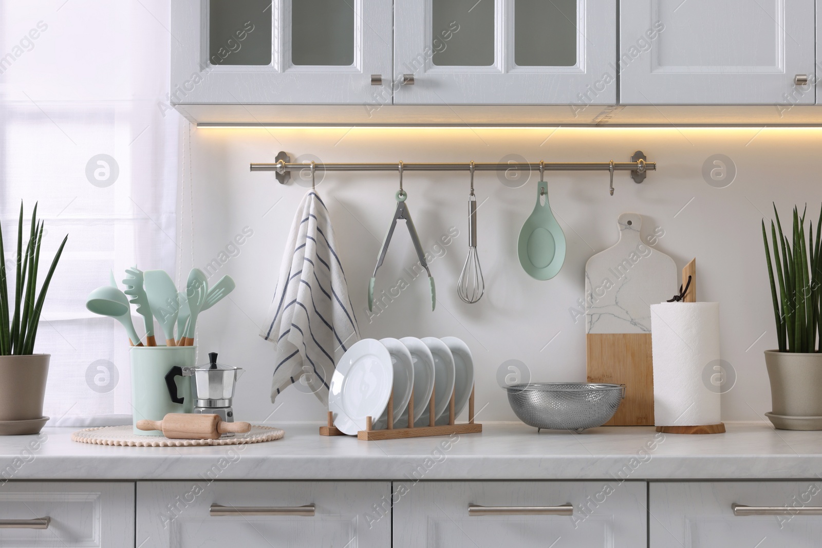 Photo of Set of different utensils and dishes on countertop in kitchen