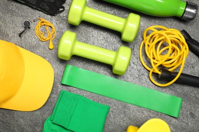 Different sports equipment on grey textured table, flat lay