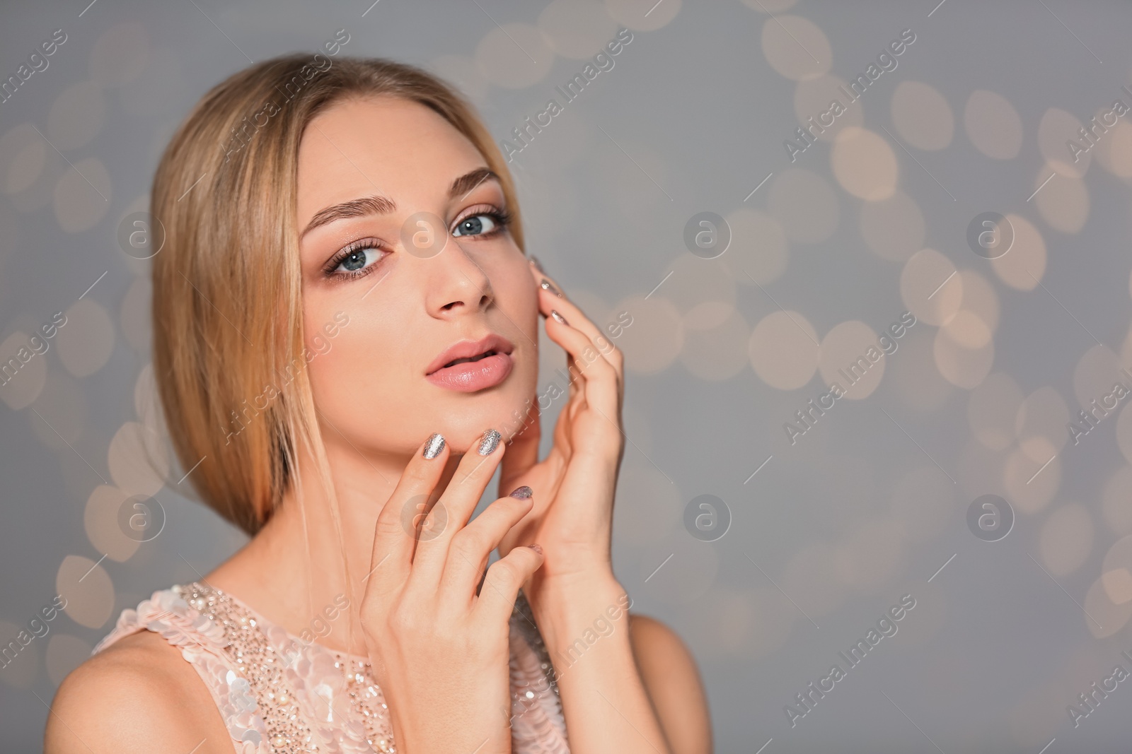 Photo of Portrait of beautiful young woman with shiny manicure on blurred background, space for text. Nail polish trends