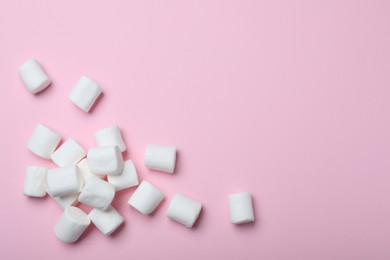 Photo of Delicious puffy marshmallows on pink background, flat lay. Space for text