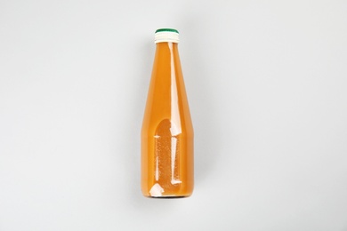 Photo of One bottle with tasty drink on color background, top view