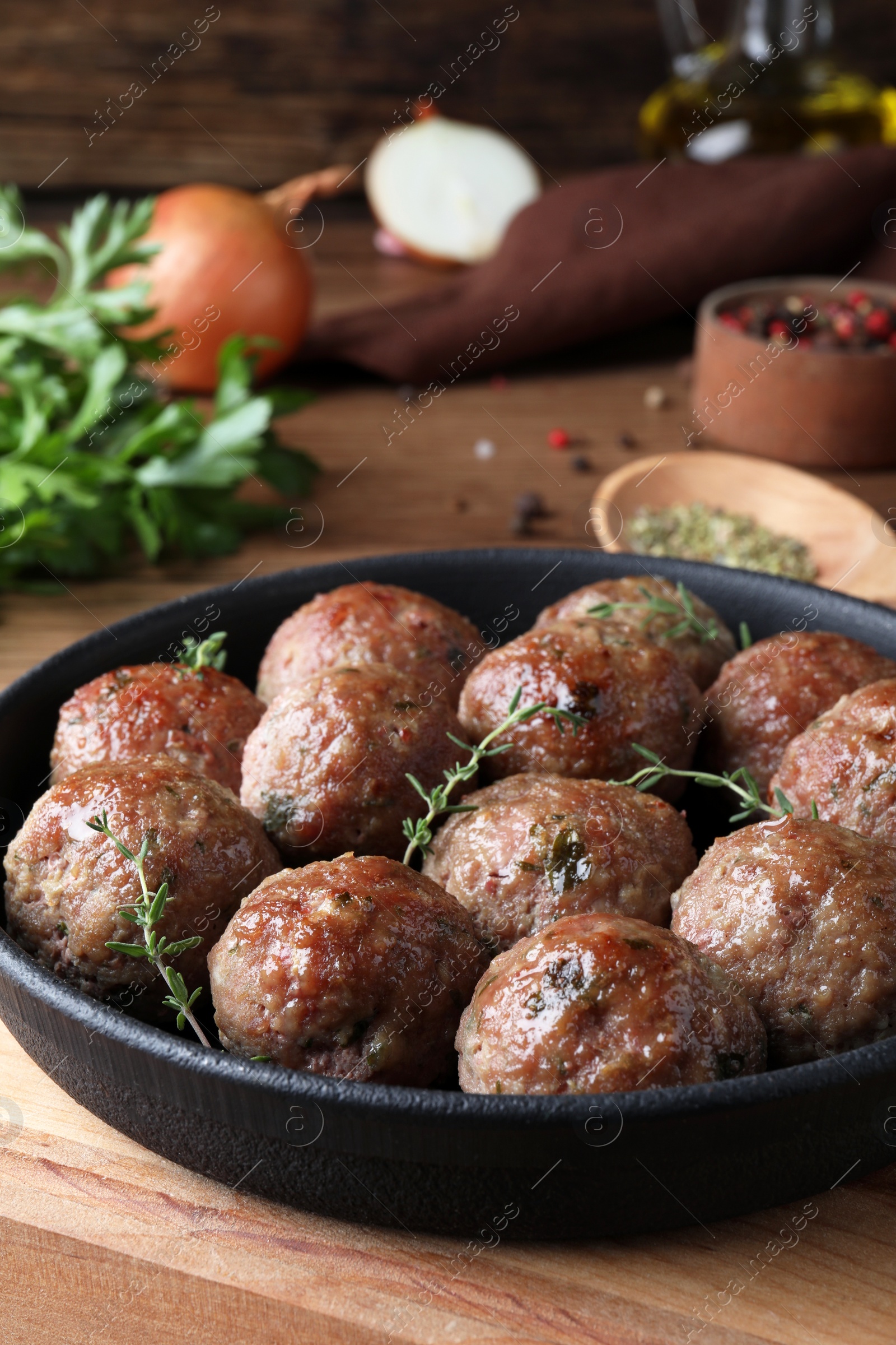 Photo of Tasty cooked meatballs served on wooden board