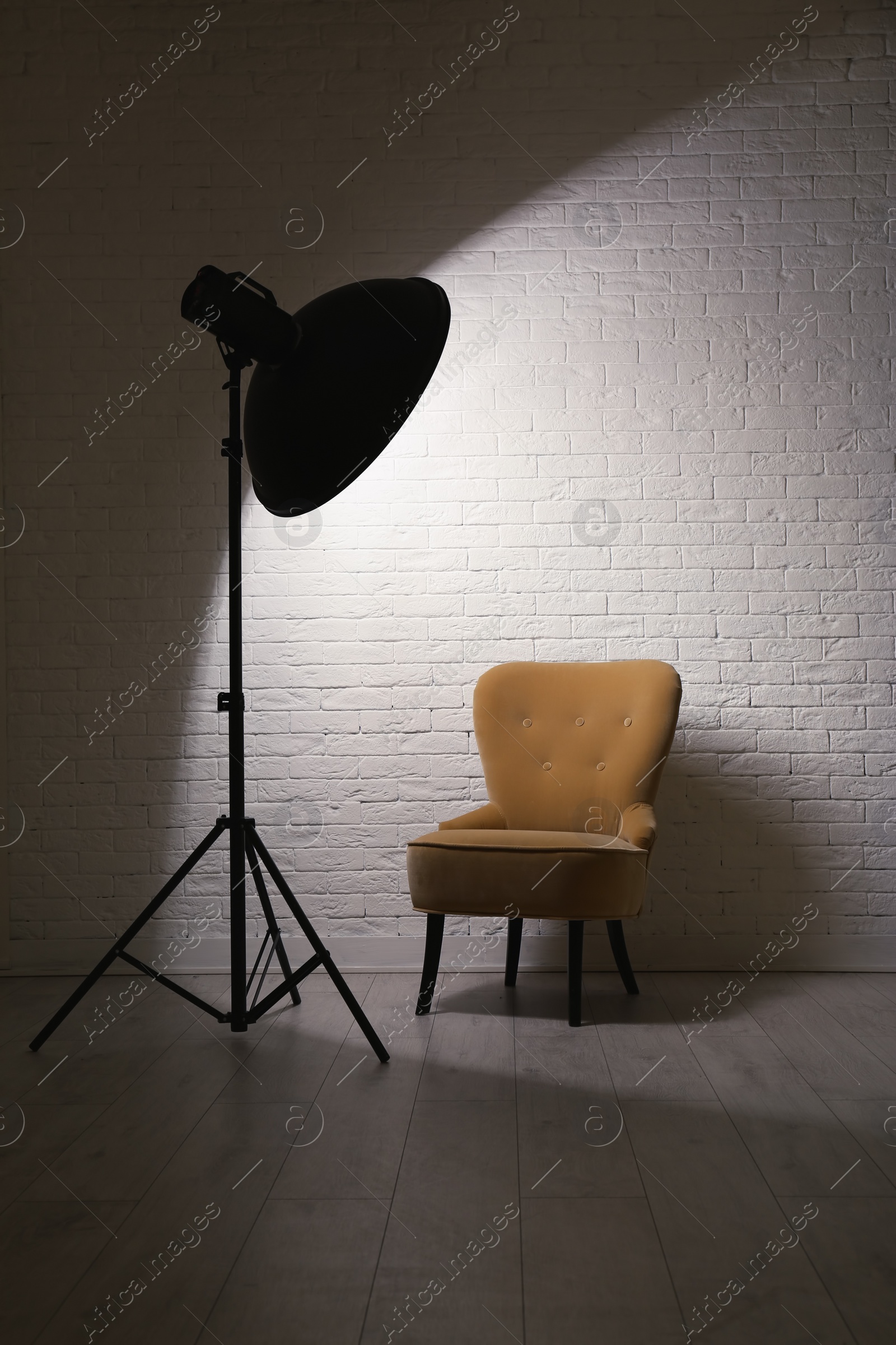 Photo of Interior of modern photo studio with professional lighting equipment and armchair