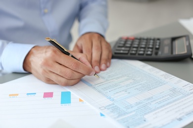 Photo of Tax accountant working with documents at table