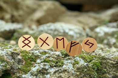 Photo of Many wooden runes on stone outdoors, closeup