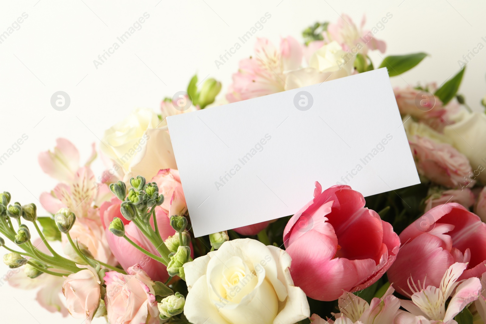 Photo of Happy Mother's Day. Beautiful flowers with blank card on light background, closeup