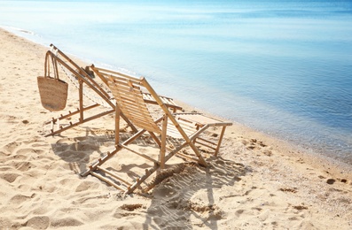 Photo of Wooden deck chairs on sandy beach near sea