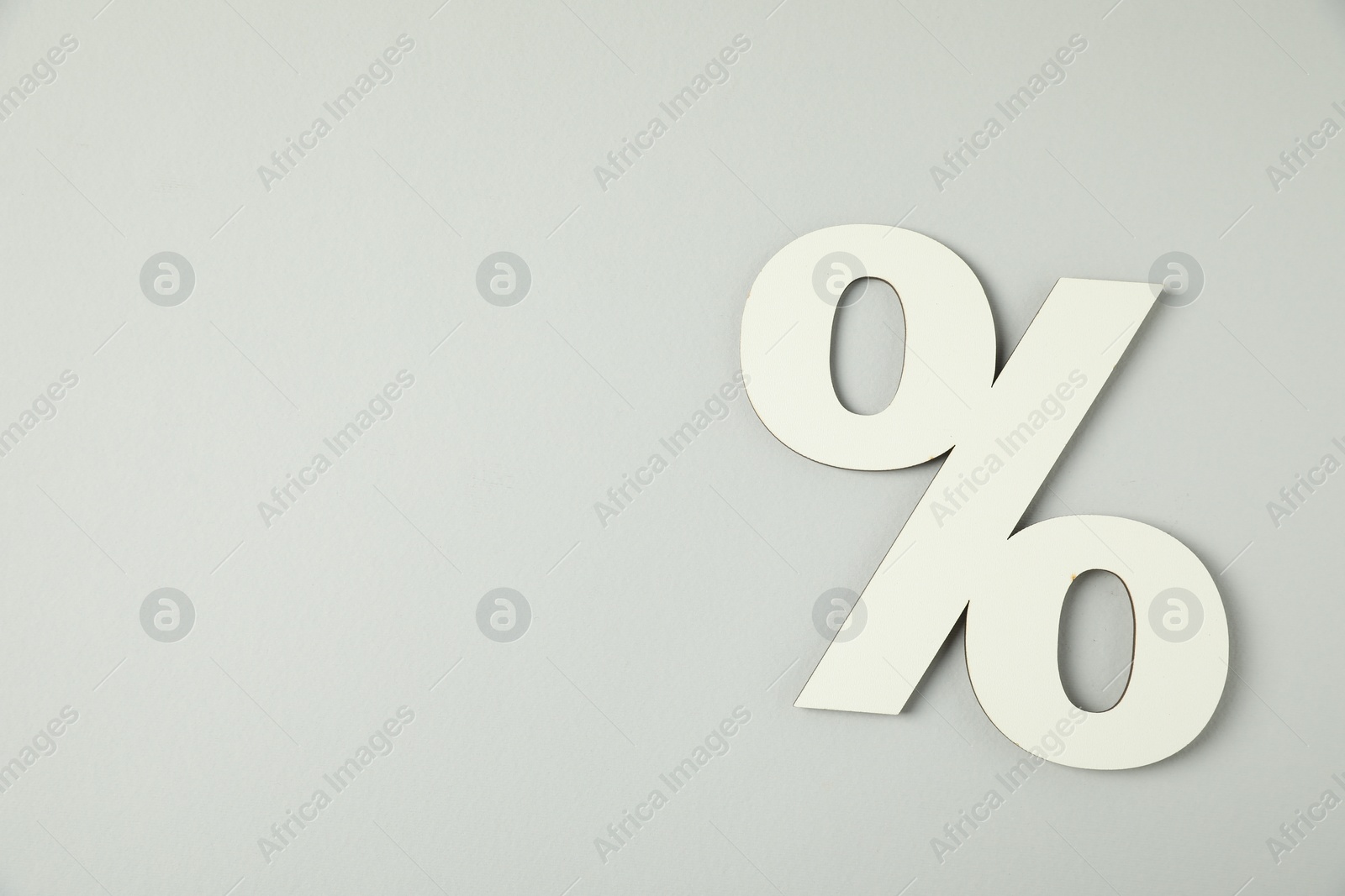 Photo of White percent sign on light grey background, top view. Space for text