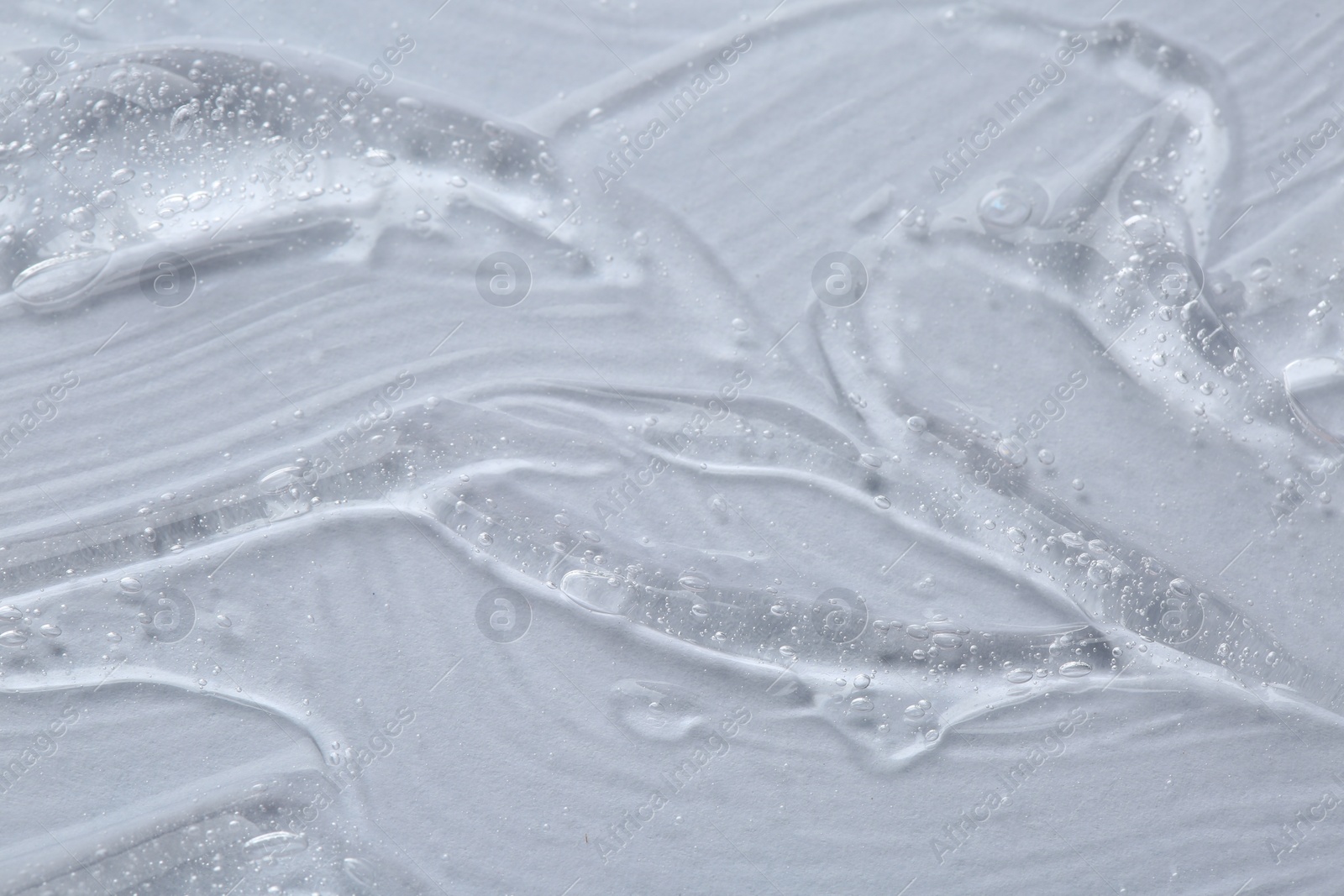 Photo of Clear cosmetic serum on white background, macro view