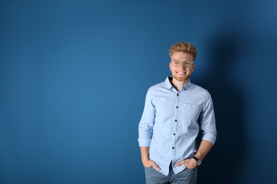 Photo of Portrait of handsome young man on blue background. Space for text